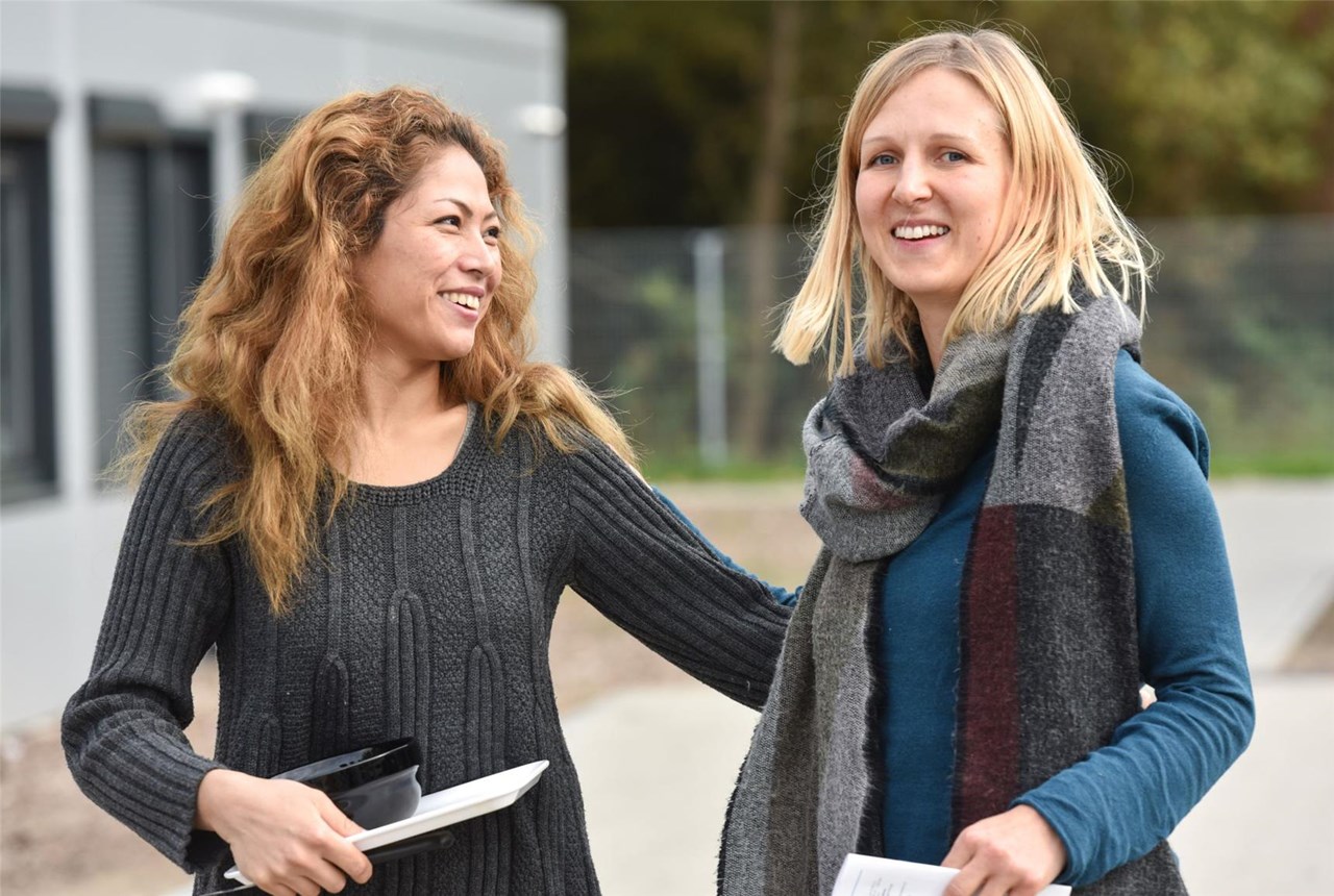 Flüchtlingsfrau und Helferin lachen