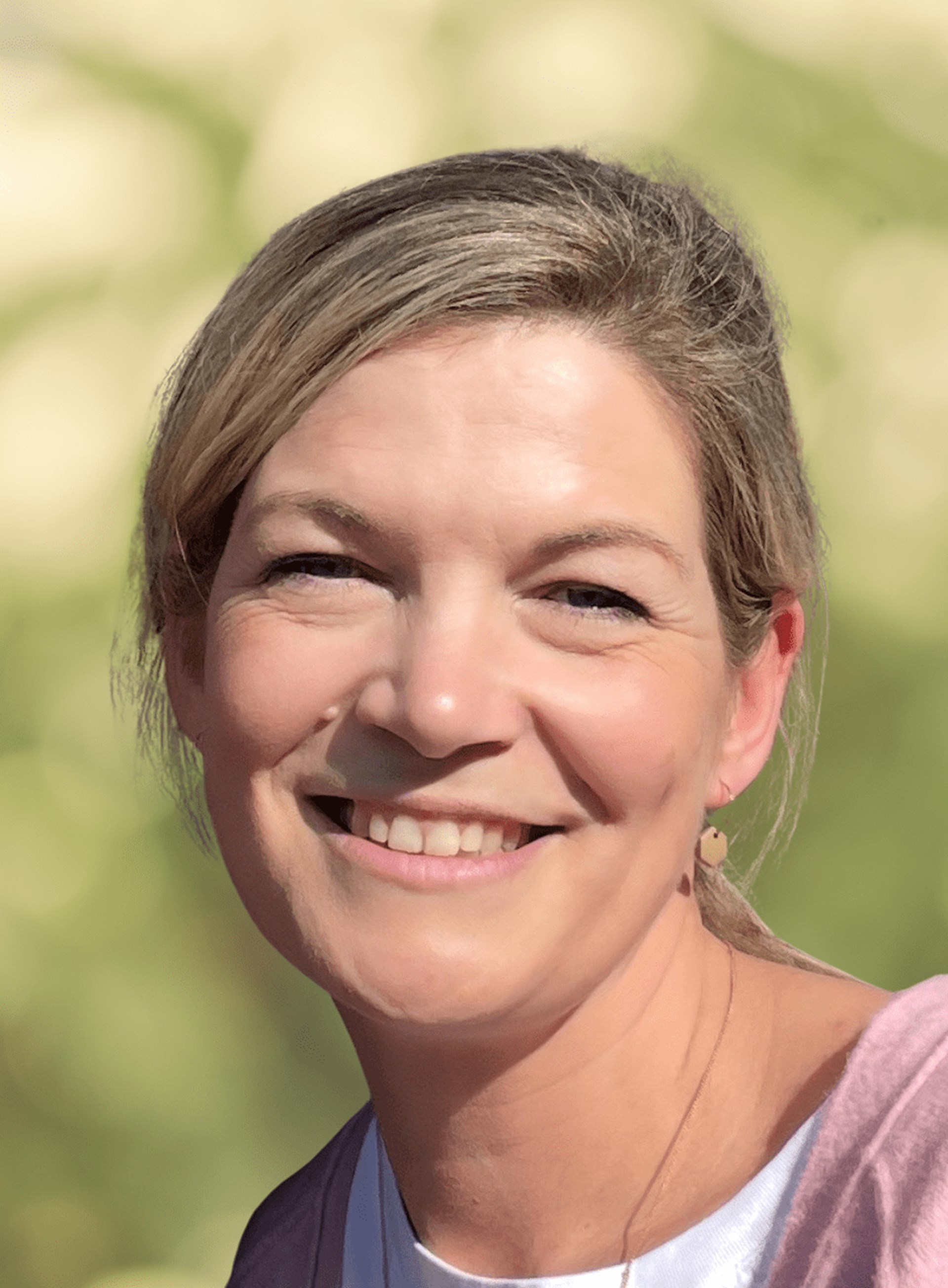 Portraitbild einer Frau mit blonden zusammengebundenen Haaren.