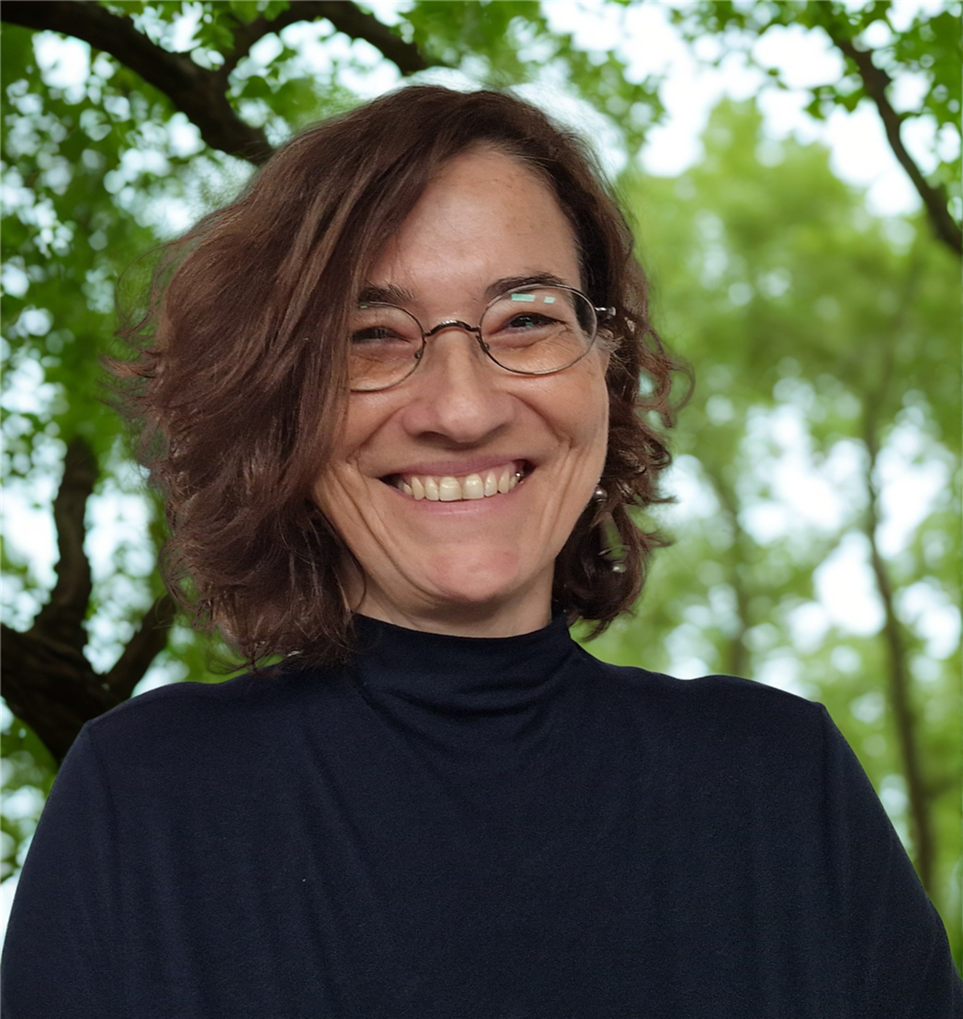 Portraitbild einer lächelnden Frau mit Brille