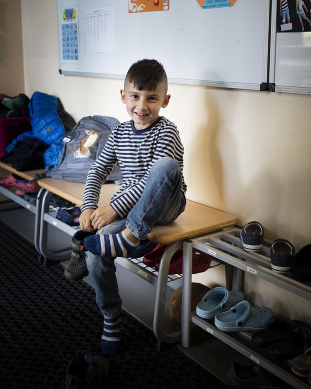 Ein Junge zieht sich seine Schuhe an