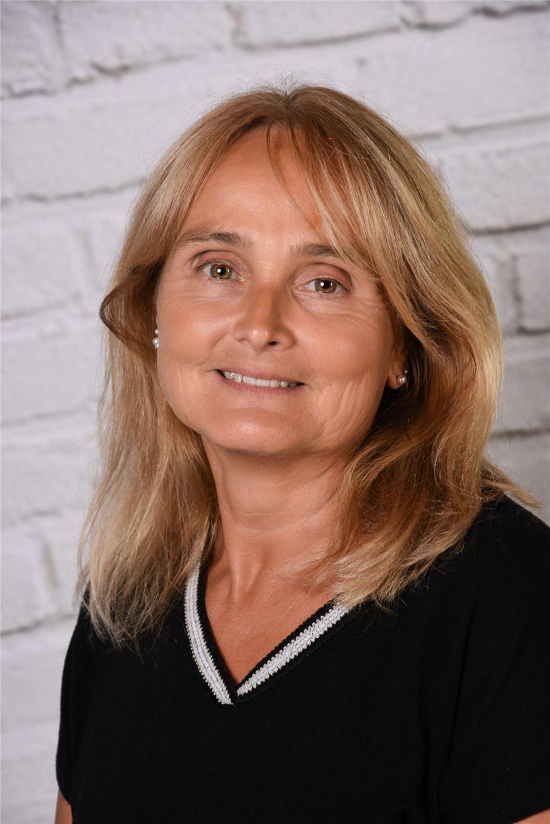 Portraitbild einer blonden Frau mit schwarzem Pulli.