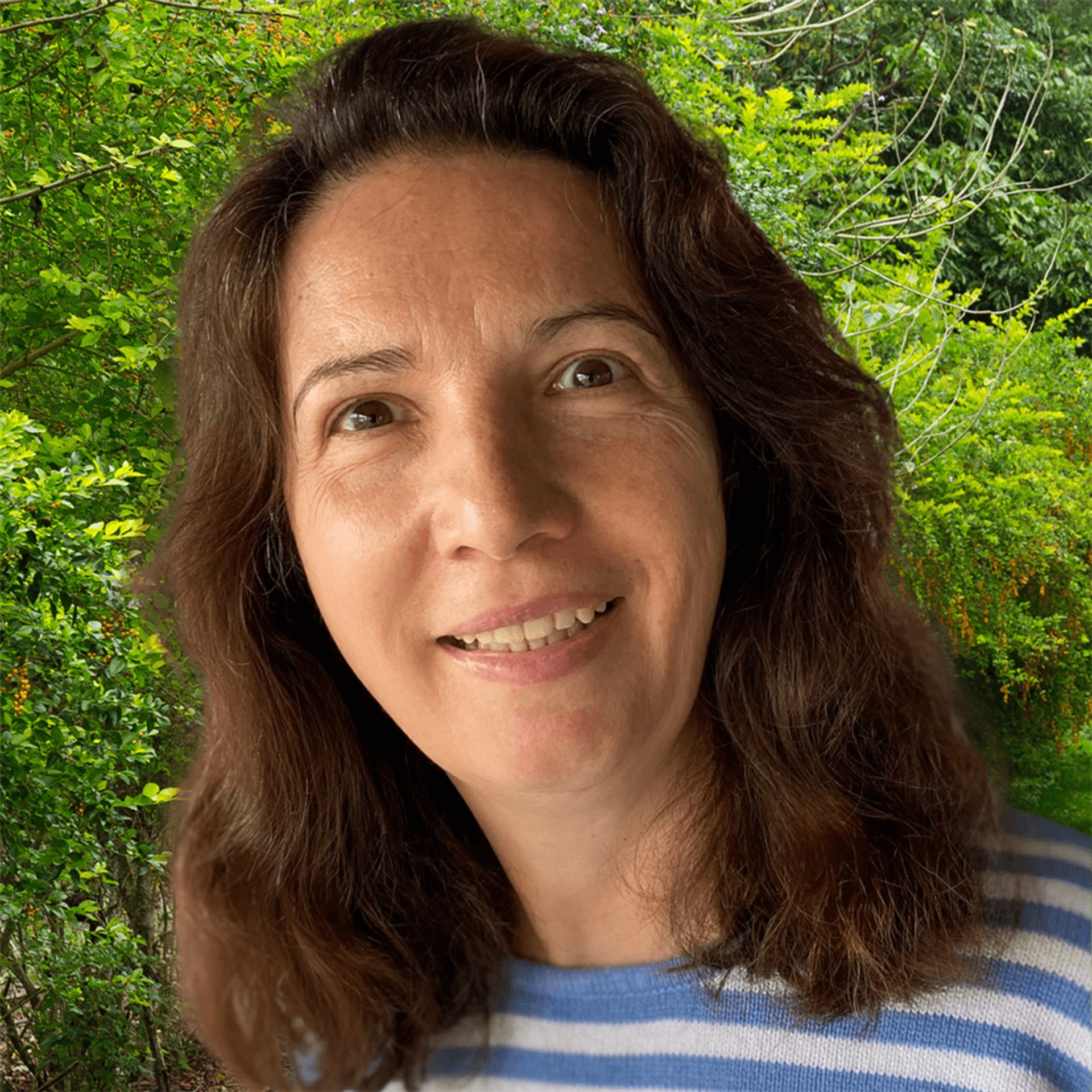 Portraitbild einer braunhaarigen Frau vor Baum